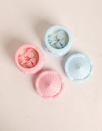 Three silicone mold containers with floral designs on a beige background